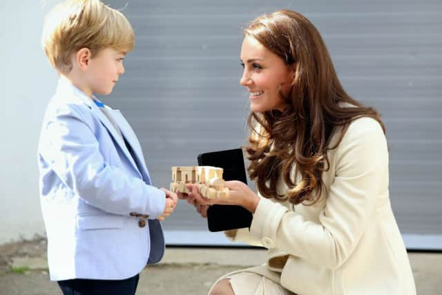 The Duchess of Cambridge is presented with a train for Prince George by actor Oliver Barker during an official visit to the set of Downton Abbey at Ealing Studios in London. PRESS ASSOCIATION Photo. Picture date: Thursday March 12, 2015. See PA story ROYAL Kate. Photo credit should read: Chris Jackson/PA Wire ROYAL_Kate_141172.JPG