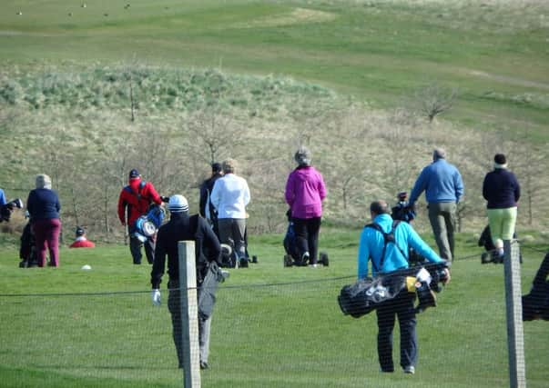 a view of the course with golfers making their way to their tee positions for a Shotgun Start