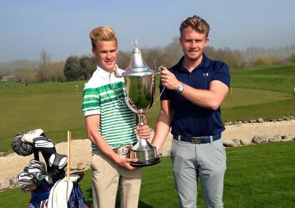 Leonard Ruggieri picks up the trophy from Chi club pro Harry Pyett