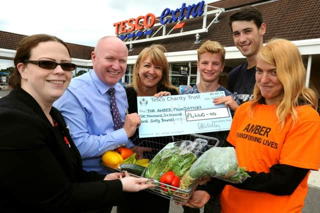 Cheque presentation from Tesco to the Amber Foundation which is based near Horsham. Tesco Customer Experience Manager Louise Sharman, and Tesco store Manager Broadbridge Heath Lee Laflain hands a cheque over to Rachel Bartlett from Amber with some of the students and (front left). Pic Steve Robards SR1516492 SUS-150715-094448001