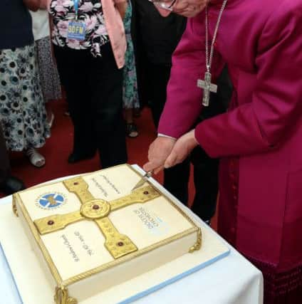 The Bishop of Chichester cuts the cake