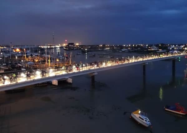 Thousands of people flock to Shoreham Tollbridge to take part in a candlelit vigil remembering those who lost their lives in the airshow crash SUS-150831-105721001