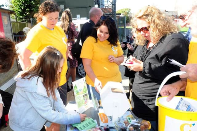 Poppy North, ten, hands out raffle tickets