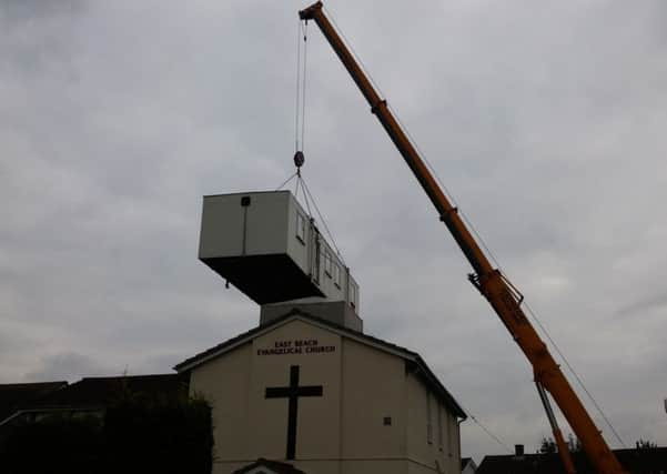 The cabin is lifted over the East Beach Evangelical Church, in Selsey. Picture by Phil Harding