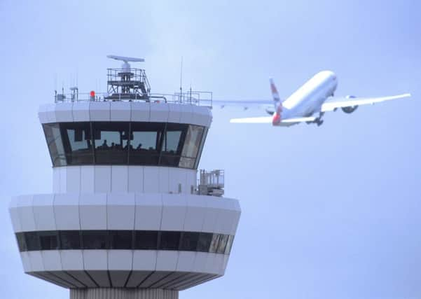 Gatwick Airport control tower with aircraft in flight in background