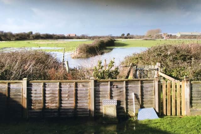 The large pool of water which is overflowing close to John's house