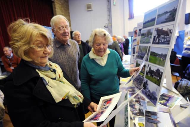 ks16000586-3 Lancing U3A Exhibit   phot kate
Co-ordinator of the walking group, Marion  Woods, Hilary Searle, and Mike Hester looking at photographs of some of the walks.ks16000586-3 SUS-160703-192823008