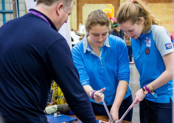 SGN Support Officer Dave Waiting with some girls from The Senior Section who are trying out the pipe activity - picture submitted