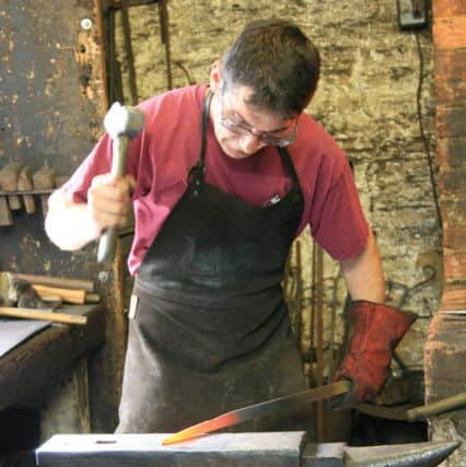 Alex at work at Chalk Pit Forge, drawing down flat