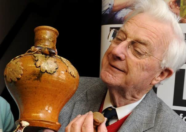 Geoffrey Godden inspecting at item at an antiques valuation day at Broadwater Manor School