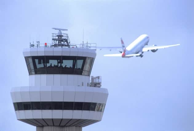 Gatwick Airport control tower with aircraft in flight in background SUS-150705-150051001