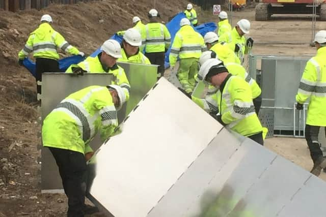 Staff setting up emergency flood response barriers