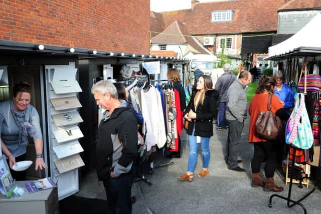 Visitors looking around the many sheds at Drapers Yard where independant sellers create and sell their products, from jewellery to ceramics, clothes, bags and art