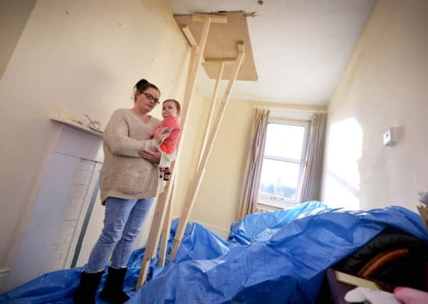 Chelsea Welch and baby Lola-Mae Middle pictured with storm damage to their flat. SUS-161121-144158001