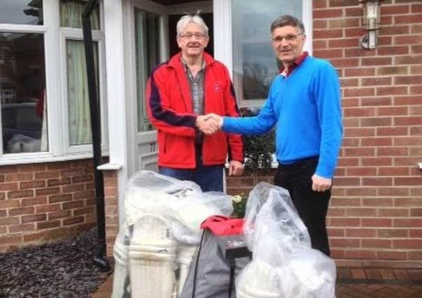 Richard Geffen hands the surplus kit to Vic Mills