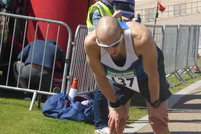 Wes Mechen catches his breath after crossing the line to win the half marathon.