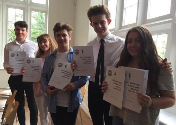 Students celebrate with their shields and certificates