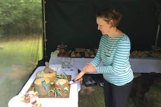 Dame Helen Ghosh cuts the cake prepared for the opening