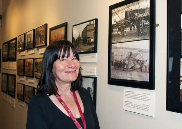 Volunteer Ruth Sluys studying a photo of Shoreham Aerodrome with a photo of a Piffard hydro aeroplane on Shoreham Beach. Picture: Derek Martin DM17737430a