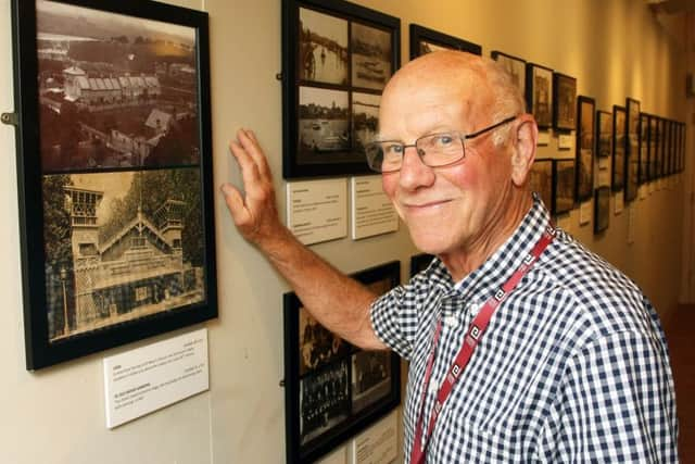 Volunteer Tony Thompson looking at a picture of the chalet-style entrance to Swiss Gardens DM17737425a