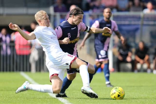 Hastings United captain Simon Johnson slides in to a tackle against Dulwich. Picture courtesy Scott White