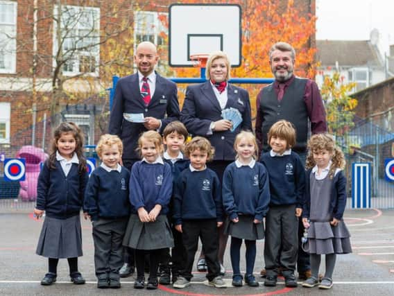 Headteacher of Fairlight Primary School Damien Jordan, and some children from the reception class receive their free tickets for British Airways i360.